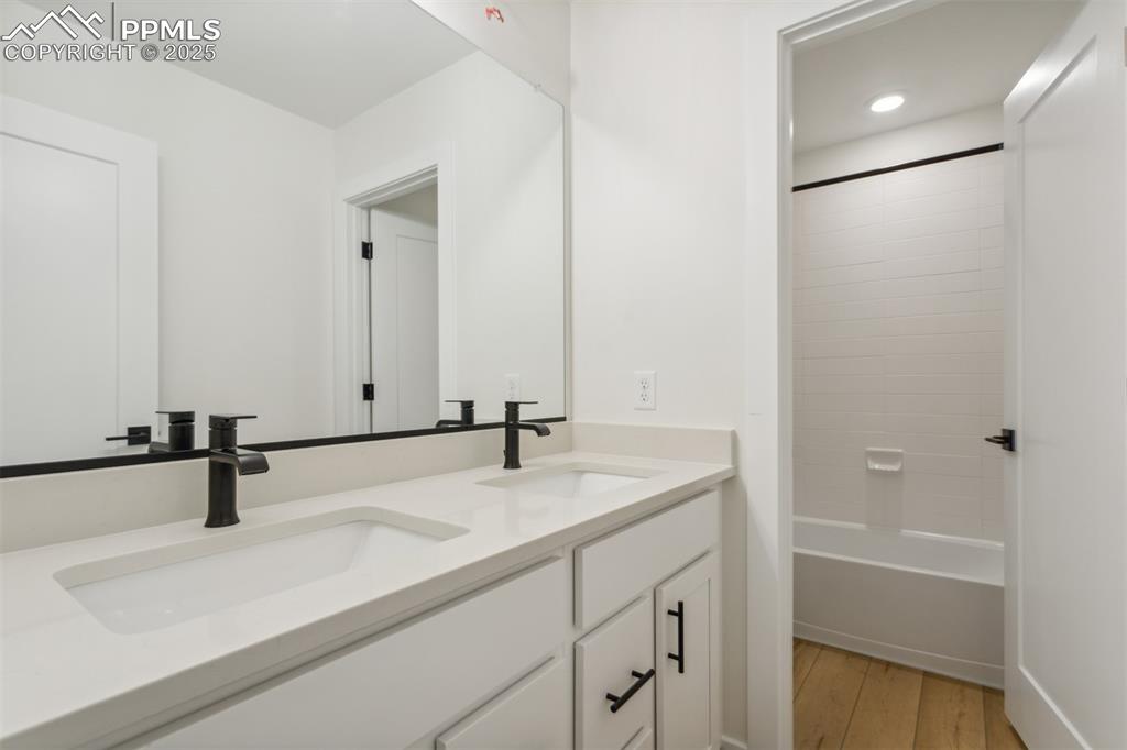 Image 12 of 19: Bathroom featuring double vanity, a sink, shower / bath combination, and wo
