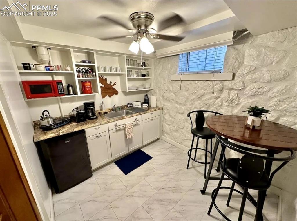 Image 10 of 16: Kitchen featuring light marble finish floors, a ceiling fan, open shelves,