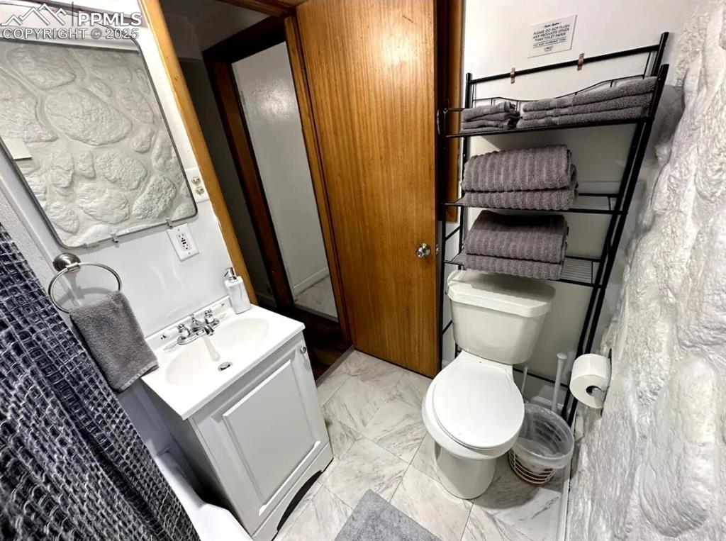 Image 11 of 16: Bathroom featuring vanity and marble look tile flooring