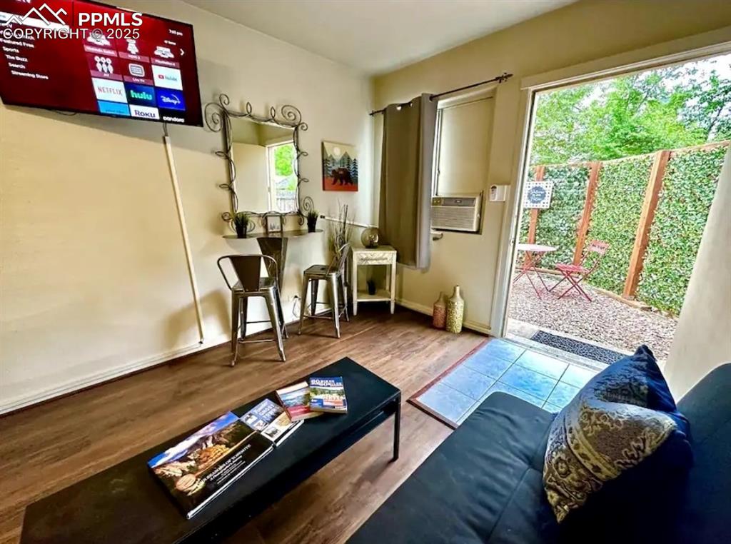 Image 13 of 16: Living room with wood finished floors and baseboards