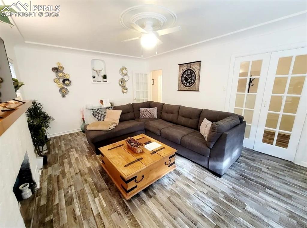 Image 6 of 16: Living room with wood finished floors and a ceiling fan
