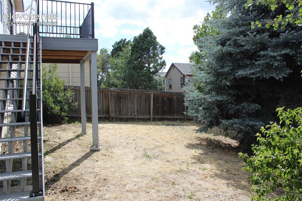 Image 19 of 23: Backyard with matures trees and new deck
