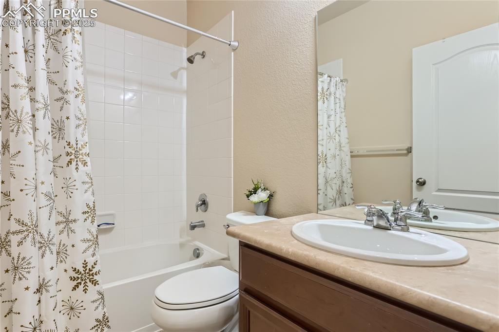 Image 19 of 28: Full bathroom with shower / bath combination with curtain, a textured wall,