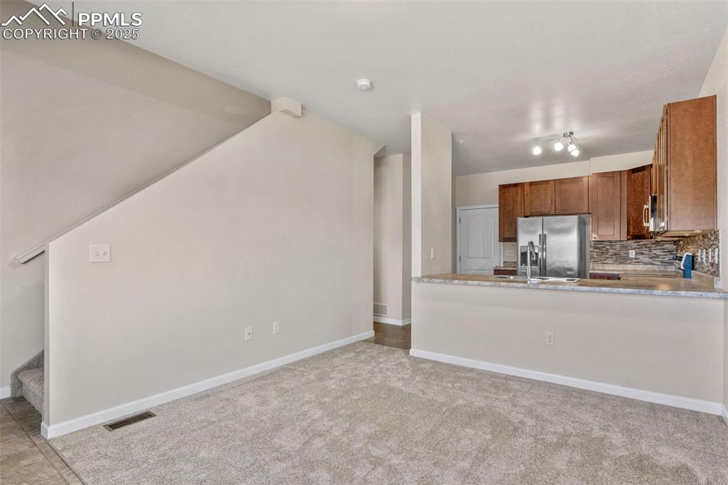 Image 10 of 41: Kitchen with tasteful backsplash, stainless steel fridge with ice dispenser