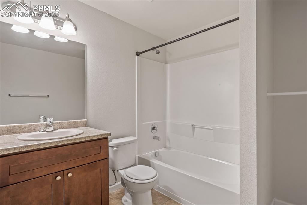 Image 27 of 41: Full bath with vanity, shower / bathtub combination, a textured wall, and l