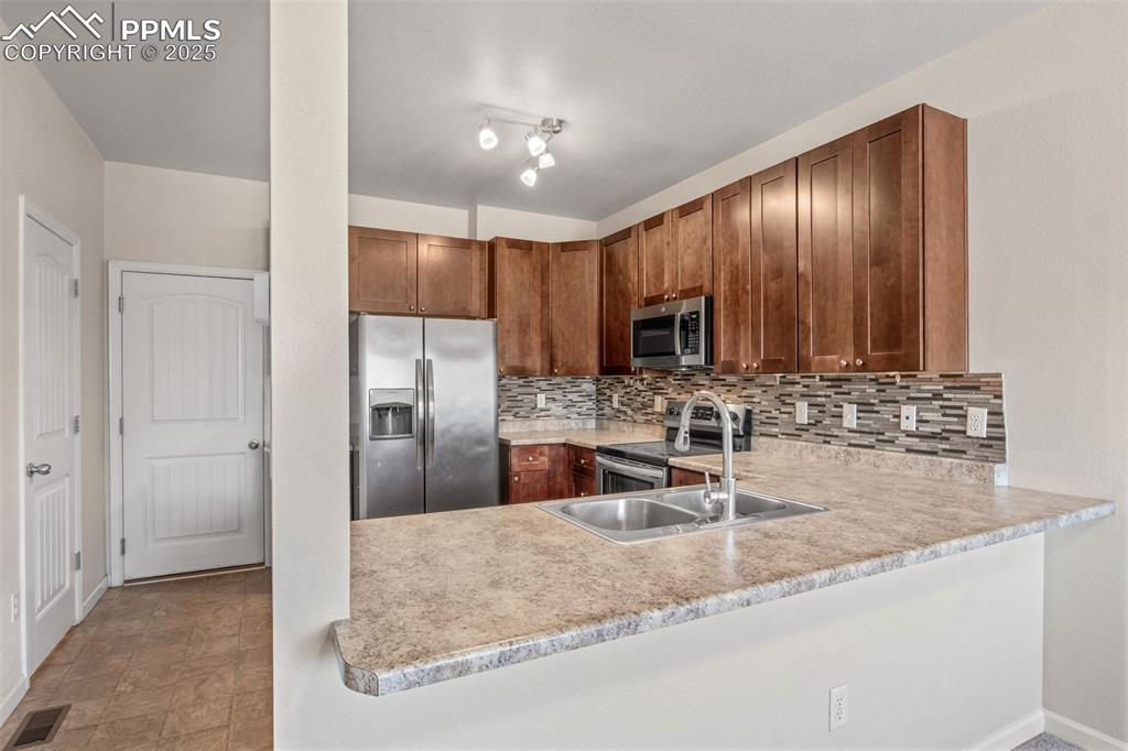Image 3 of 41: Kitchen with appliances with stainless steel finishes, tasteful backsplash,