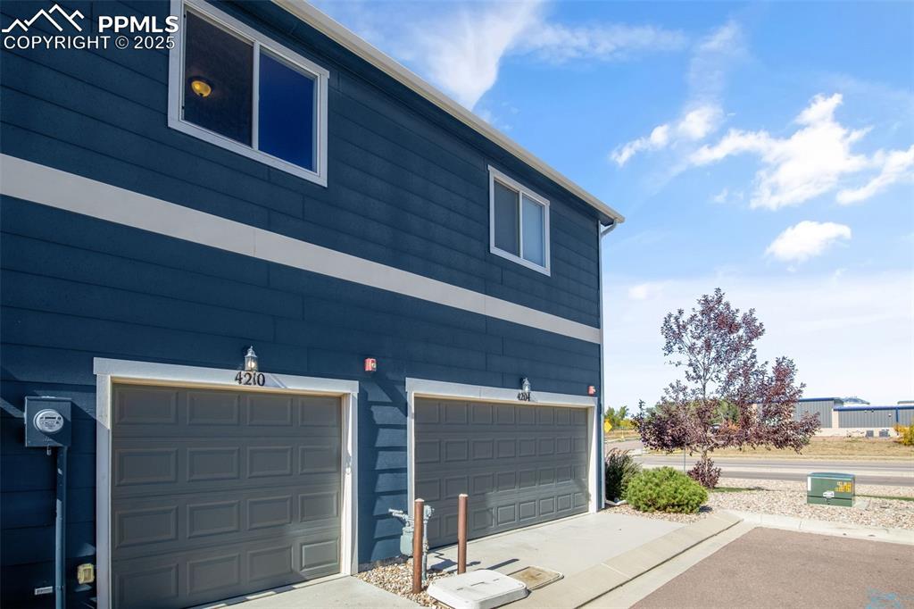 Image 40 of 41: View of side of property featuring a garage and driveway