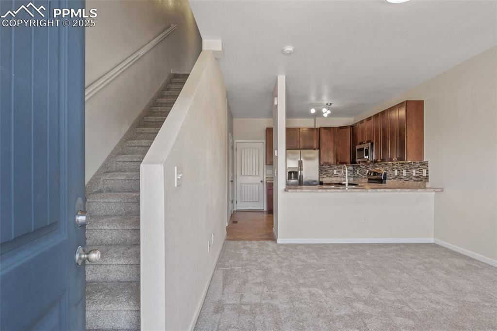 Image 6 of 41: Kitchen with decorative backsplash, appliances with stainless steel finishe