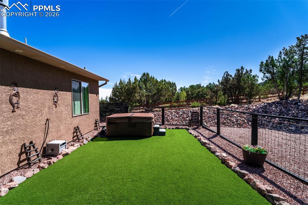 Image 30 of 50: Fully fenced yard with astro turf.