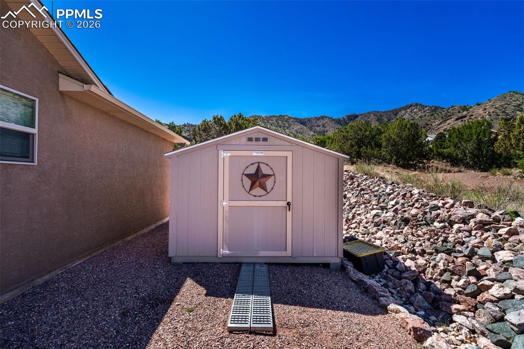 Image 34 of 50: Tuff Shed on side of home