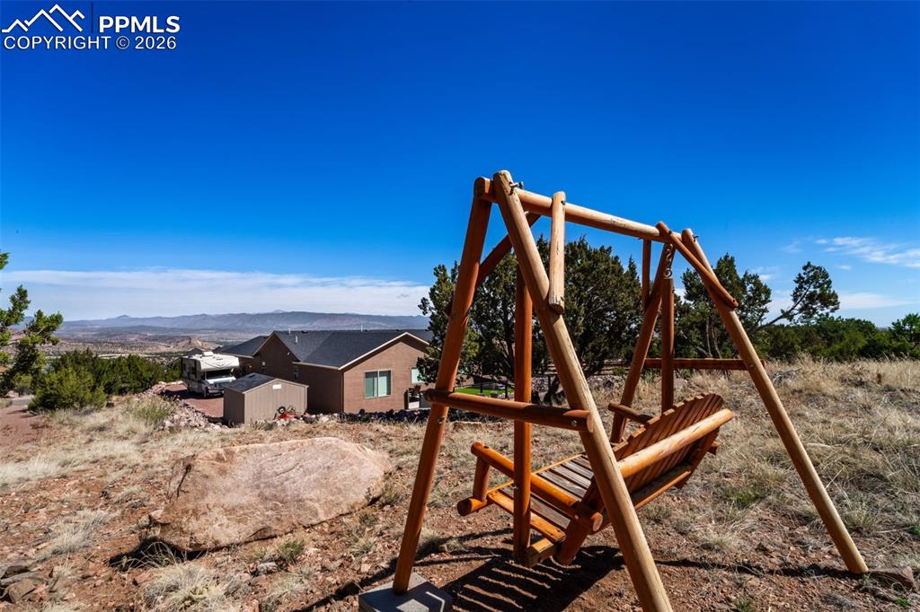 Image 36 of 50: View from back of property with included wooden swing