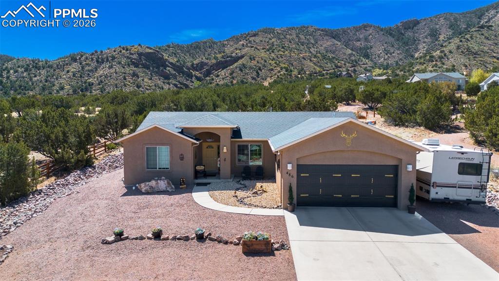 Image 37 of 50: View of front of property with stucco siding, a mountain view, concrete dri