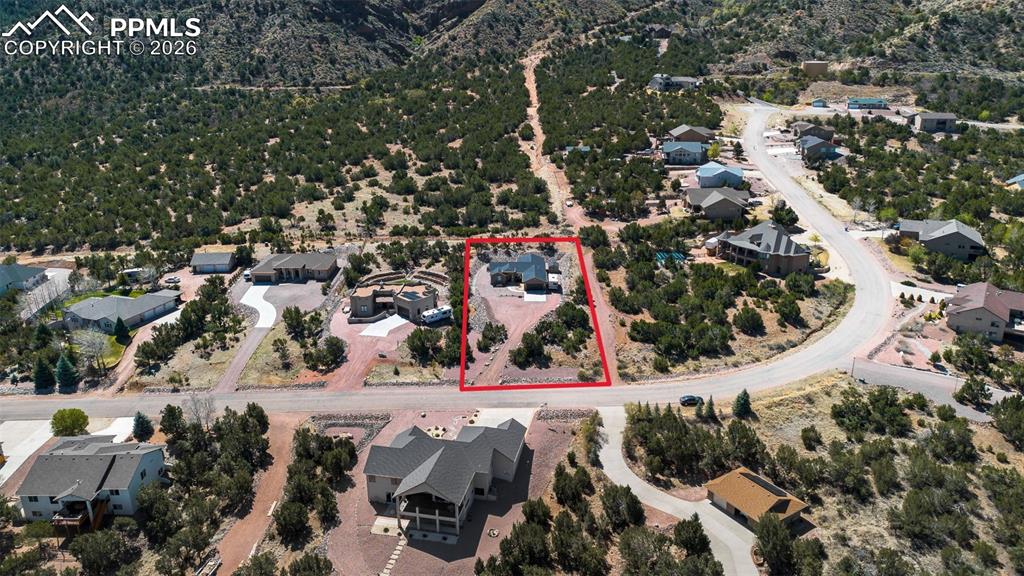 Image 45 of 50: Aerial perspective of suburban area with property parcel outlined and a mou