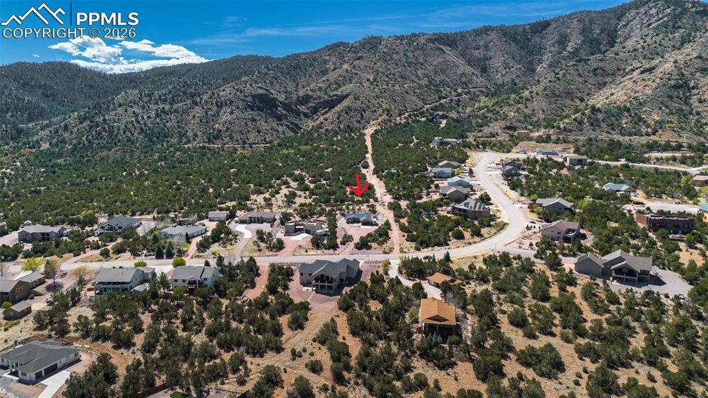 Image 47 of 50: Aerial view of residential area with a mountain backdrop
