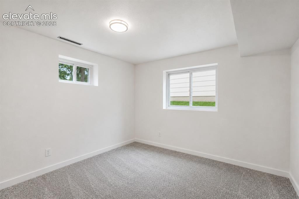 Image 32 of 47: Neutral tone walls with gray patterned carpeting