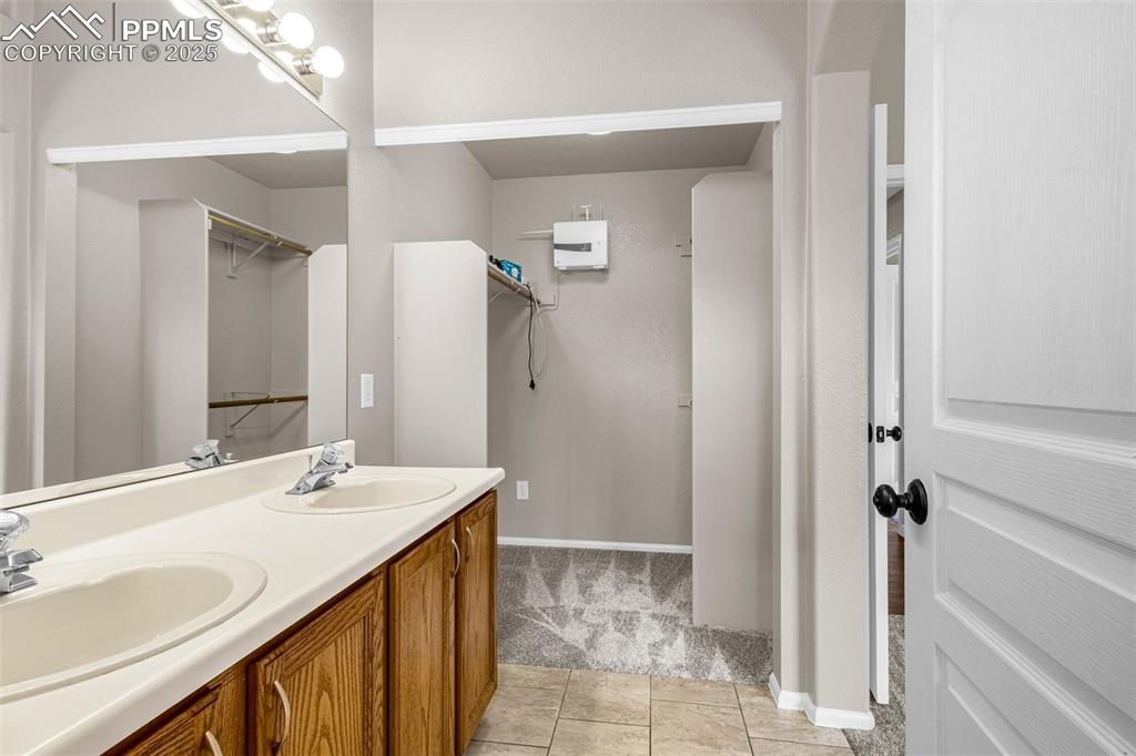 Image 16 of 38: Full bath with double vanity and tile patterned floors
