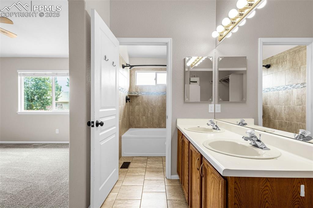 Image 18 of 38: Bathroom featuring double vanity, shower / tub combination, a ceiling fan,