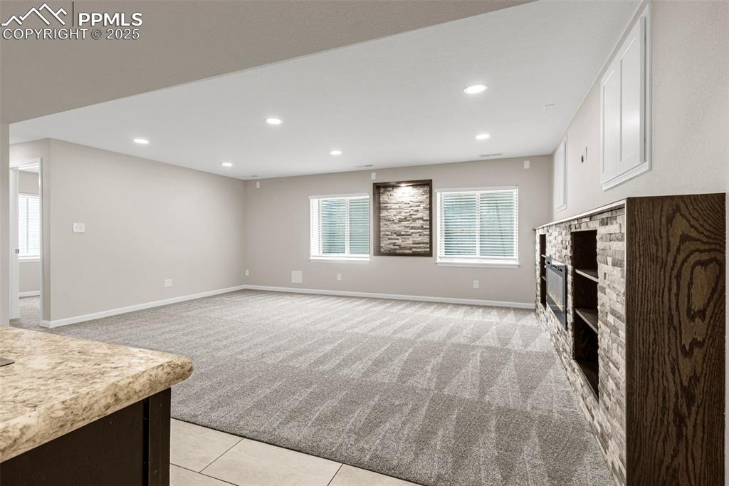 Image 22 of 38: Unfurnished living room with light colored carpet, recessed lighting, a fir