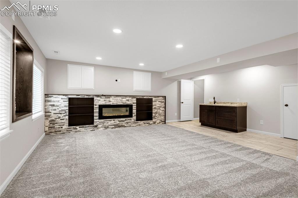 Image 23 of 38: Unfurnished living room with light colored carpet, recessed lighting, and a