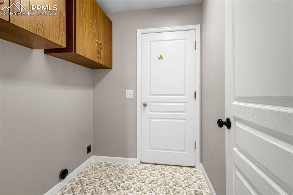 Image 27 of 38: Laundry room featuring cabinet space and baseboards