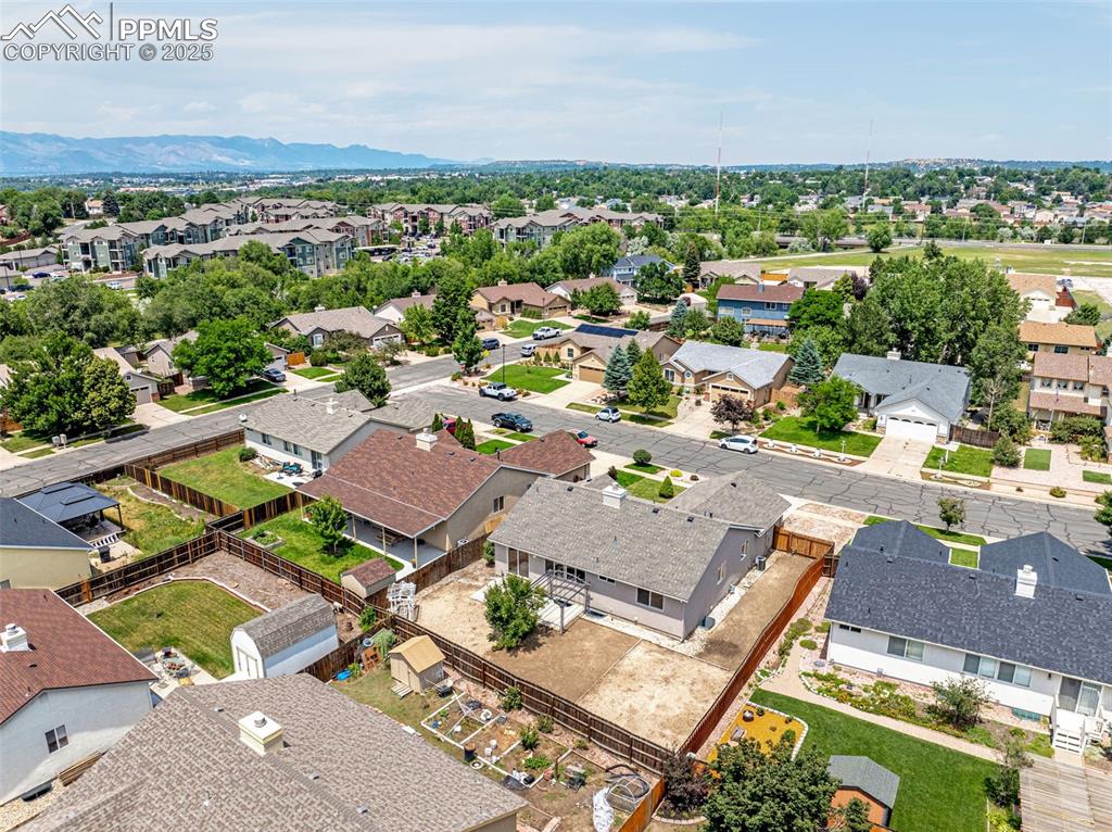 Image 34 of 38: Aerial view of residential area featuring a mountainous background
