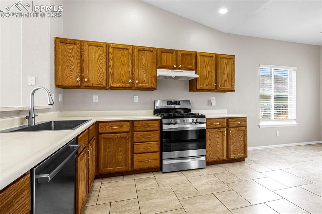 Image 9 of 38: Kitchen featuring appliances with stainless steel finishes, brown cabinets,