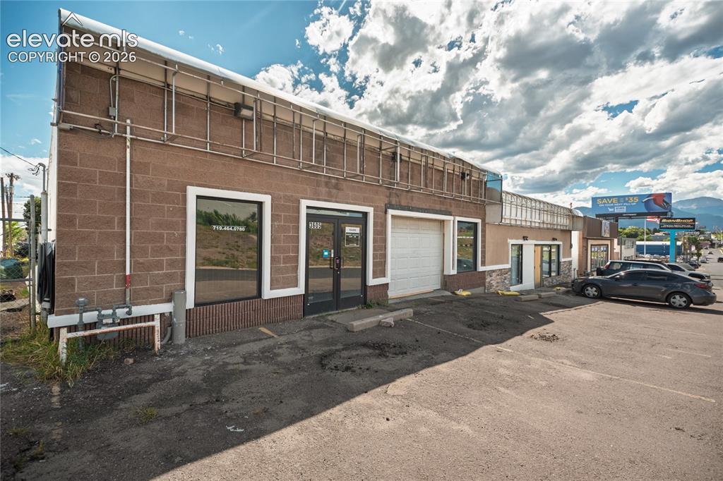 Image 2 of 50: Masonry block construction with a large glass storefront and additional dri