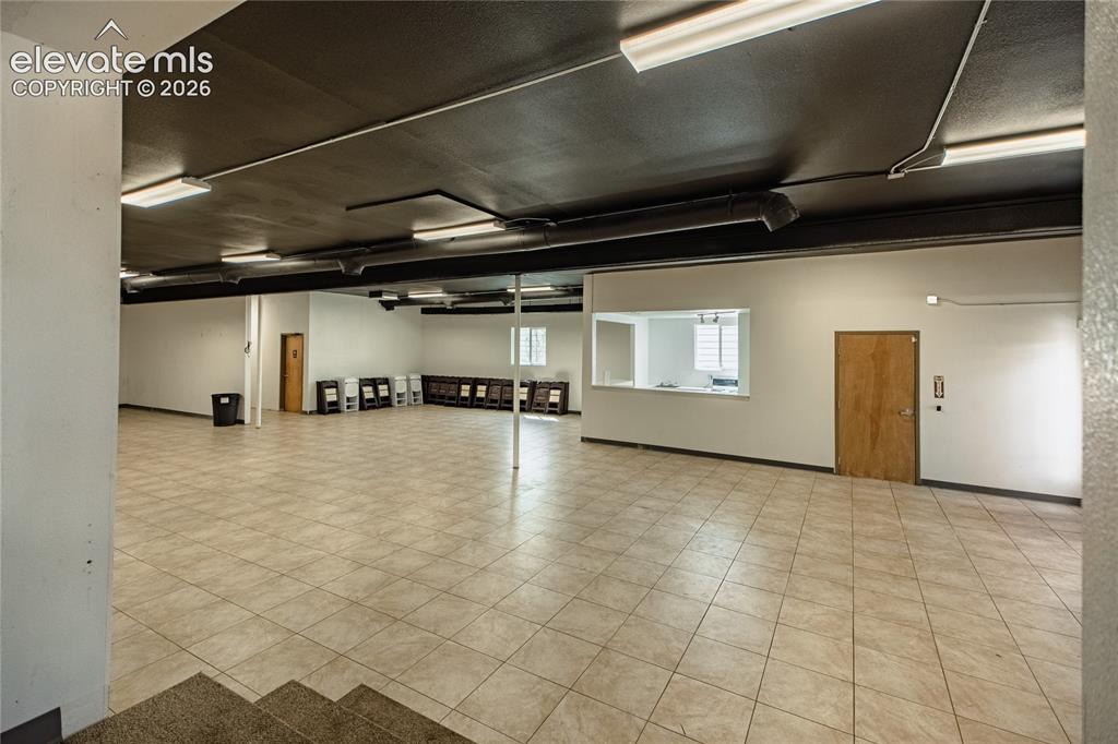 Image 21 of 50: Expansive open-concept room featuring tiled flooring, a suspended ceiling w