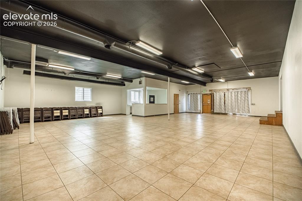 Image 25 of 50: Expansive open-concept space featuring ceramic tile flooring, a painted bla