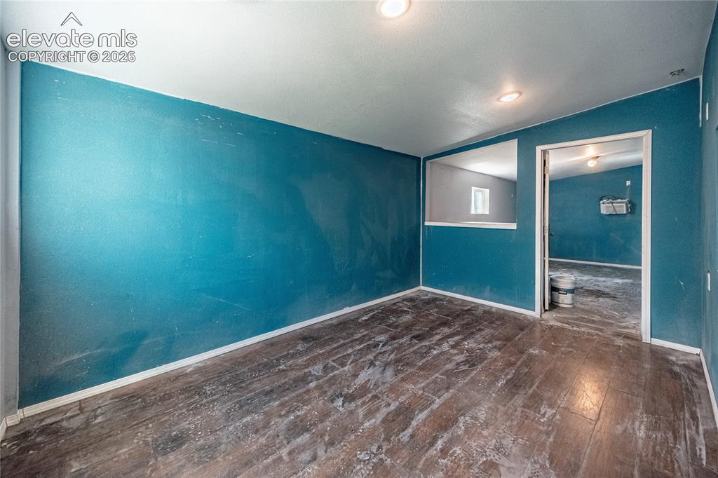 Image 33 of 50: Wood-finish flooring with a teal wall finish