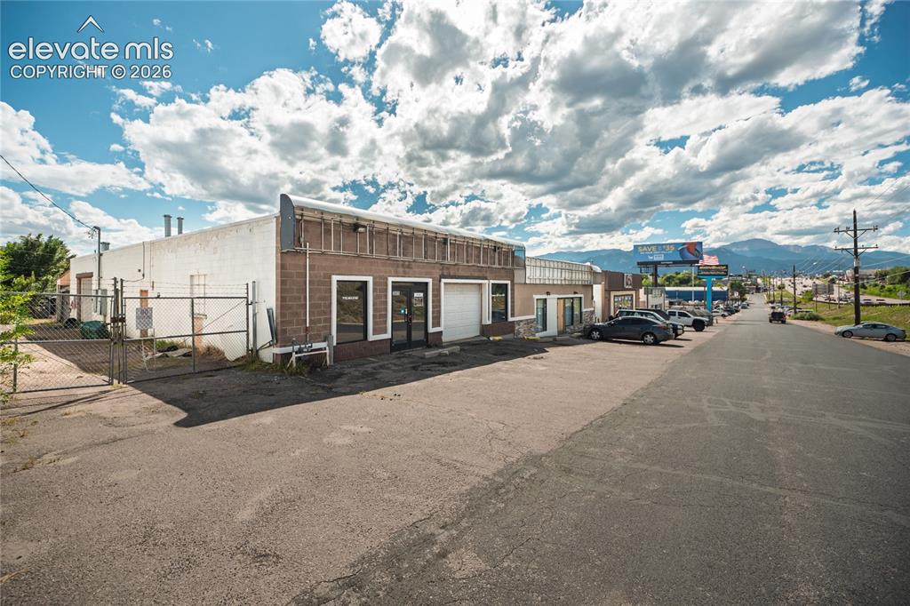 Image 4 of 50: Commercial property featuring a brick facade, white stucco exterior, multip