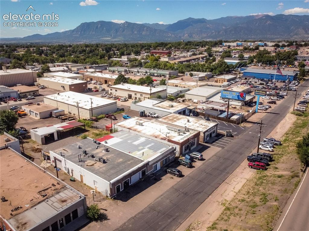 Image 50 of 50: Commercial buildings with flat roofs, paved parking areas, and surrounding 