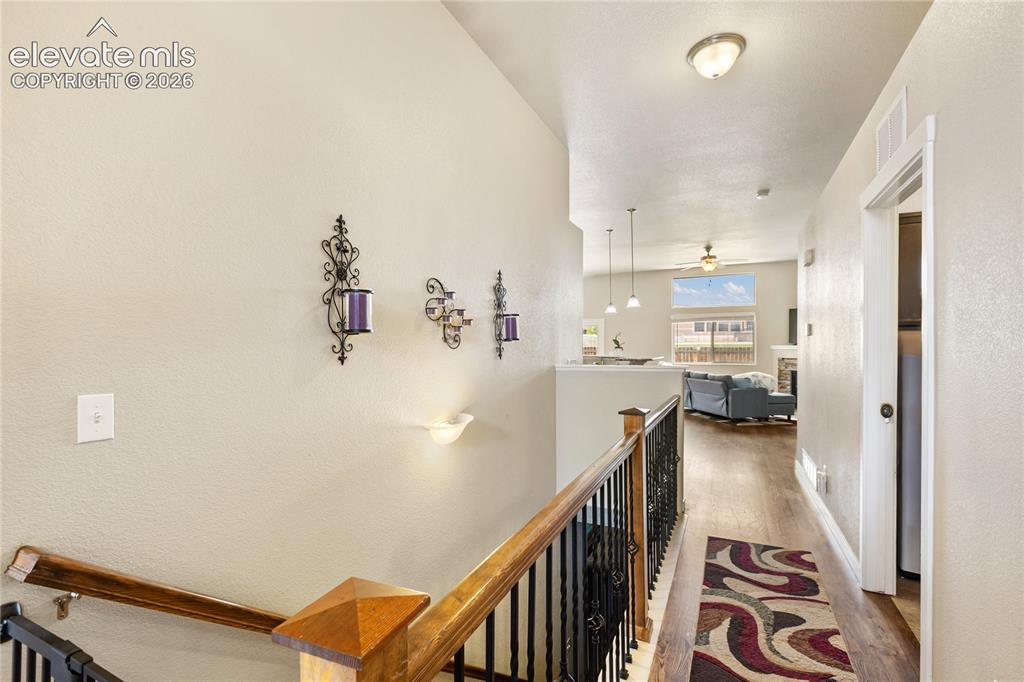 Image 11 of 32: Welcoming entry featuring hardwood flooring and staircase with wood handrai