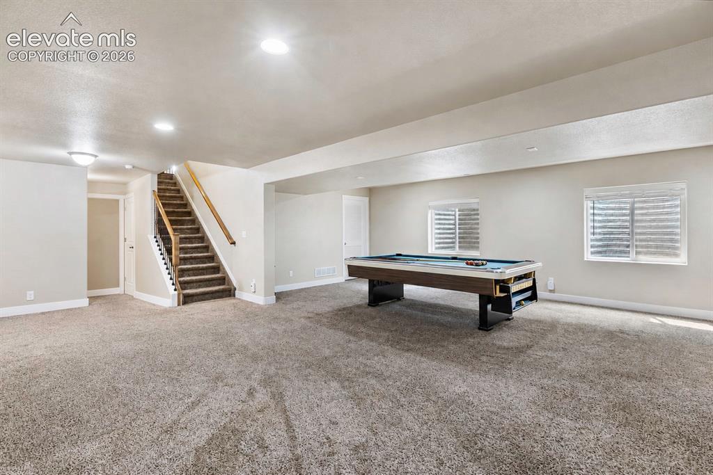 Image 17 of 32: Spacious lower-level area featuring plush gray carpeting, recessed lighting