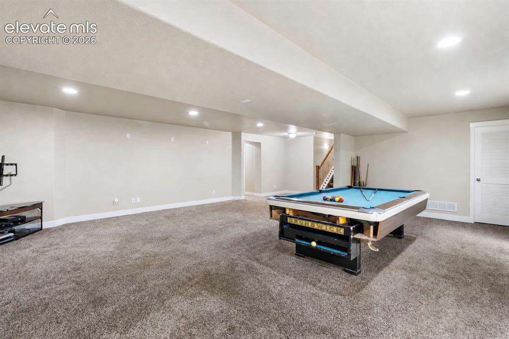 Image 18 of 32: Expansive recreational space featuring plush gray carpeting, recessed light