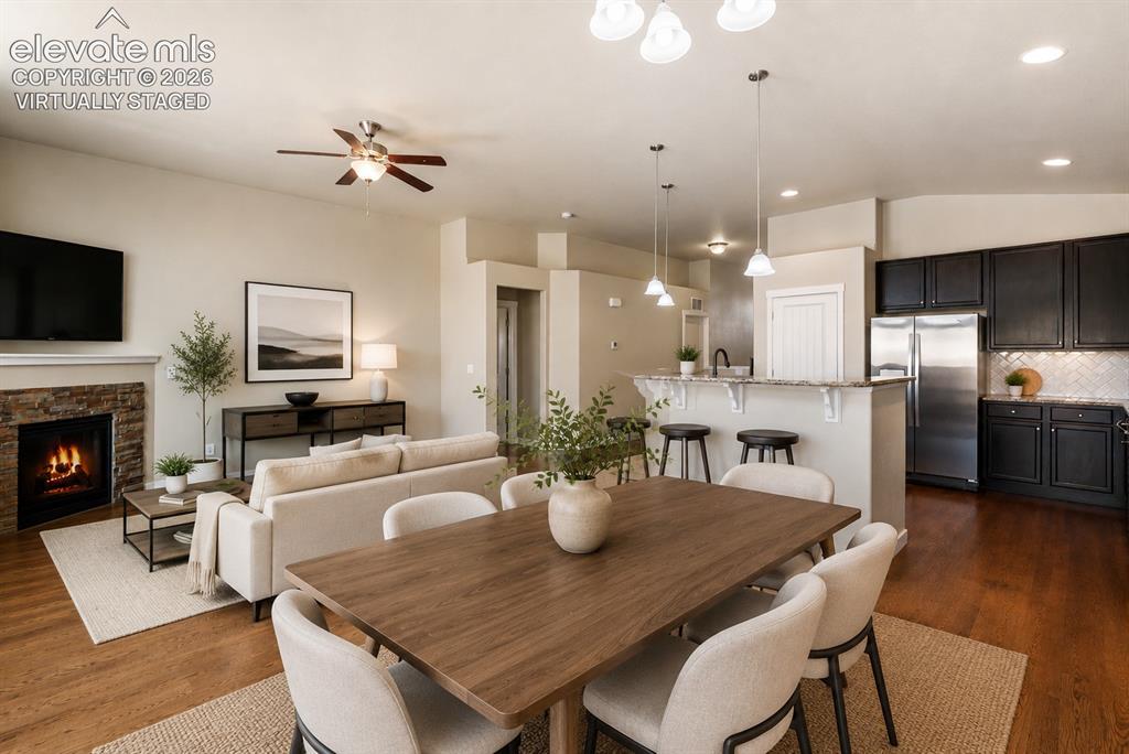 Image 2 of 32: Expansive open-concept living space featuring wood-finish flooring, a stone