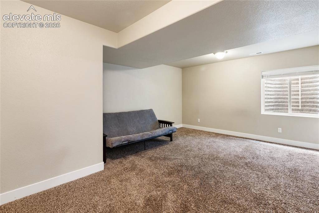 Image 20 of 32: Oversized basement bedroom with flexible living space.