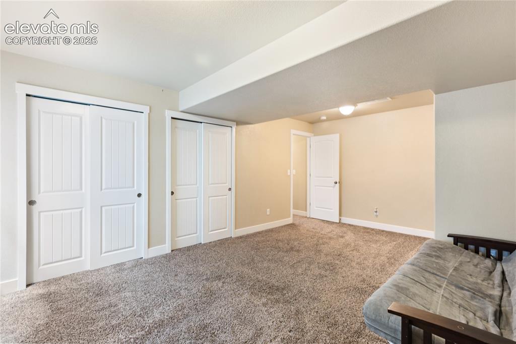 Image 21 of 32: Oversized basement bedroom with flexible living space.