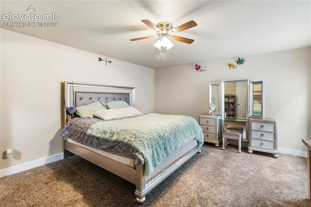 Image 23 of 32: Carpeted bedroom featuring neutral wall tones and white baseboards