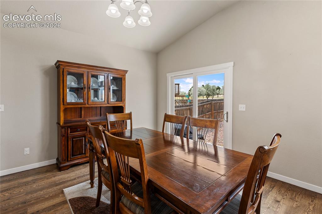 Image 29 of 32: Dining area with high ceilings, wood-finish flooring, and light-toned wall