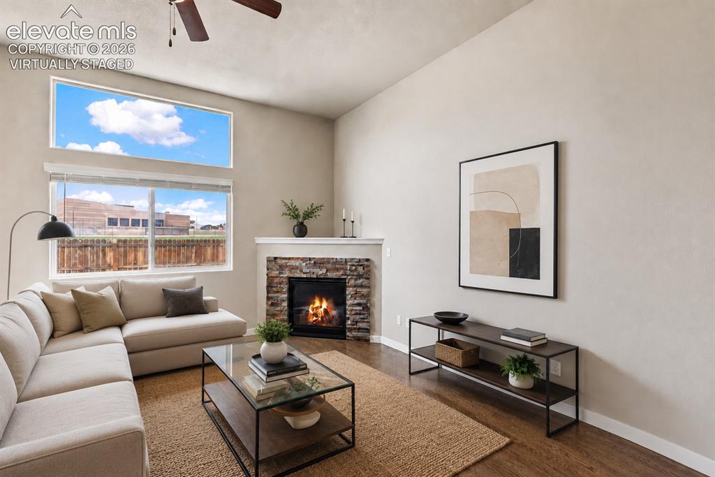 Image 4 of 32: Living room featuring a stone-clad fireplace with a white mantel, wood-fini