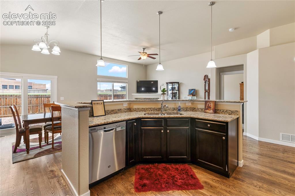 Image 5 of 32: Kitchen featuring warm wood cabinetry, a breakfast bar, and generous counte