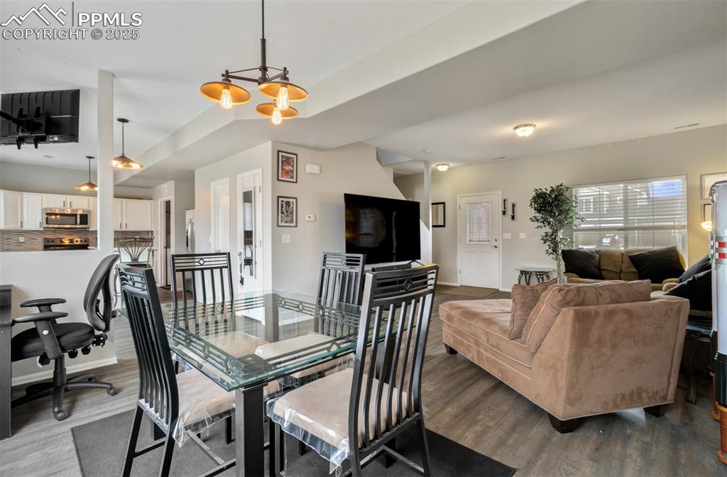 Image 10 of 35: Dining space featuring baseboards, wood finished floors, and a chandelier