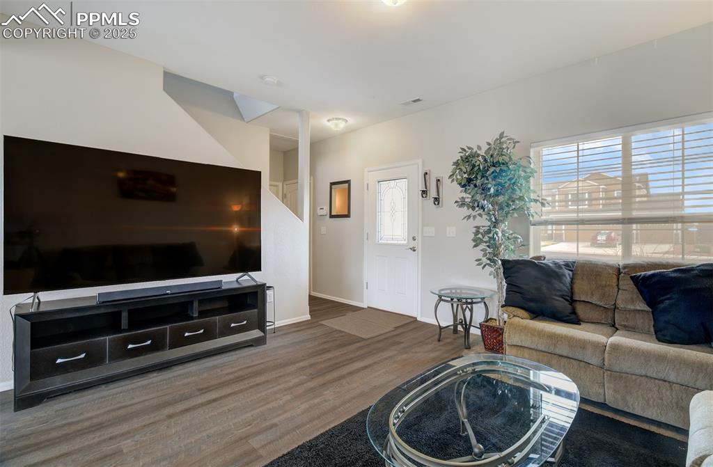 Image 12 of 35: Living area with baseboards and wood finished floors