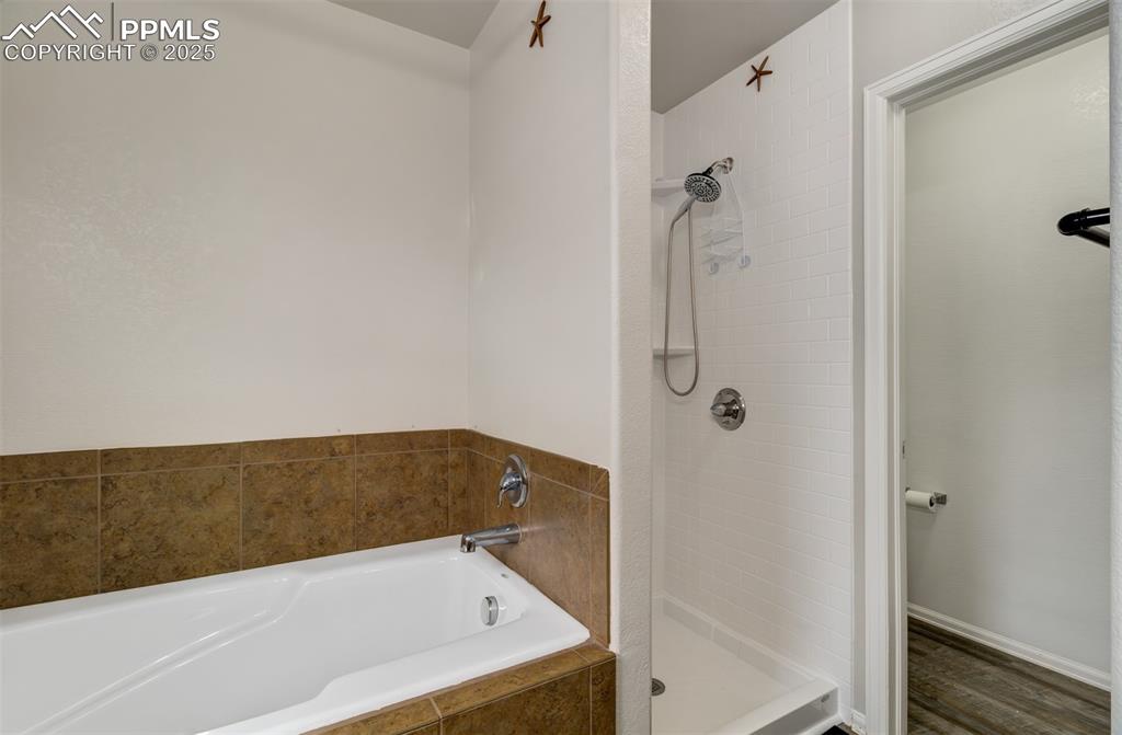Image 25 of 35: Bathroom with a tile shower and a garden tub