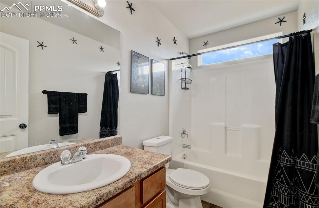 Image 27 of 35: Full bath with toilet, vanity, and shower / bath combination with curtain