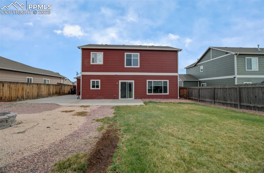 Image 29 of 35: Back of property with a lawn, a fenced backyard, and a patio area
