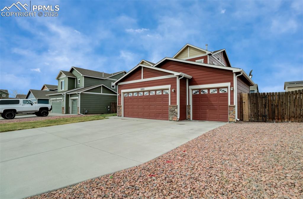 Image 34 of 35: View of front of property featuring stone siding, driveway, a garage, and f