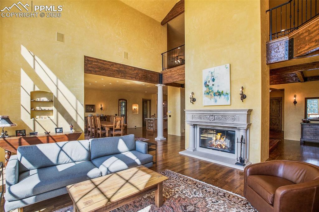Image 10 of 50: Living room featuring dark, hardwood flooring, ornate columns, high vaulted