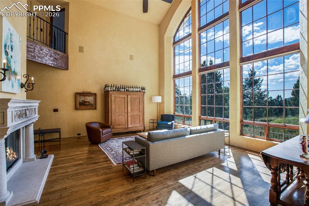 Image 11 of 50: Living room with high vaulted ceiling, dark hardwood flooring, and a high e